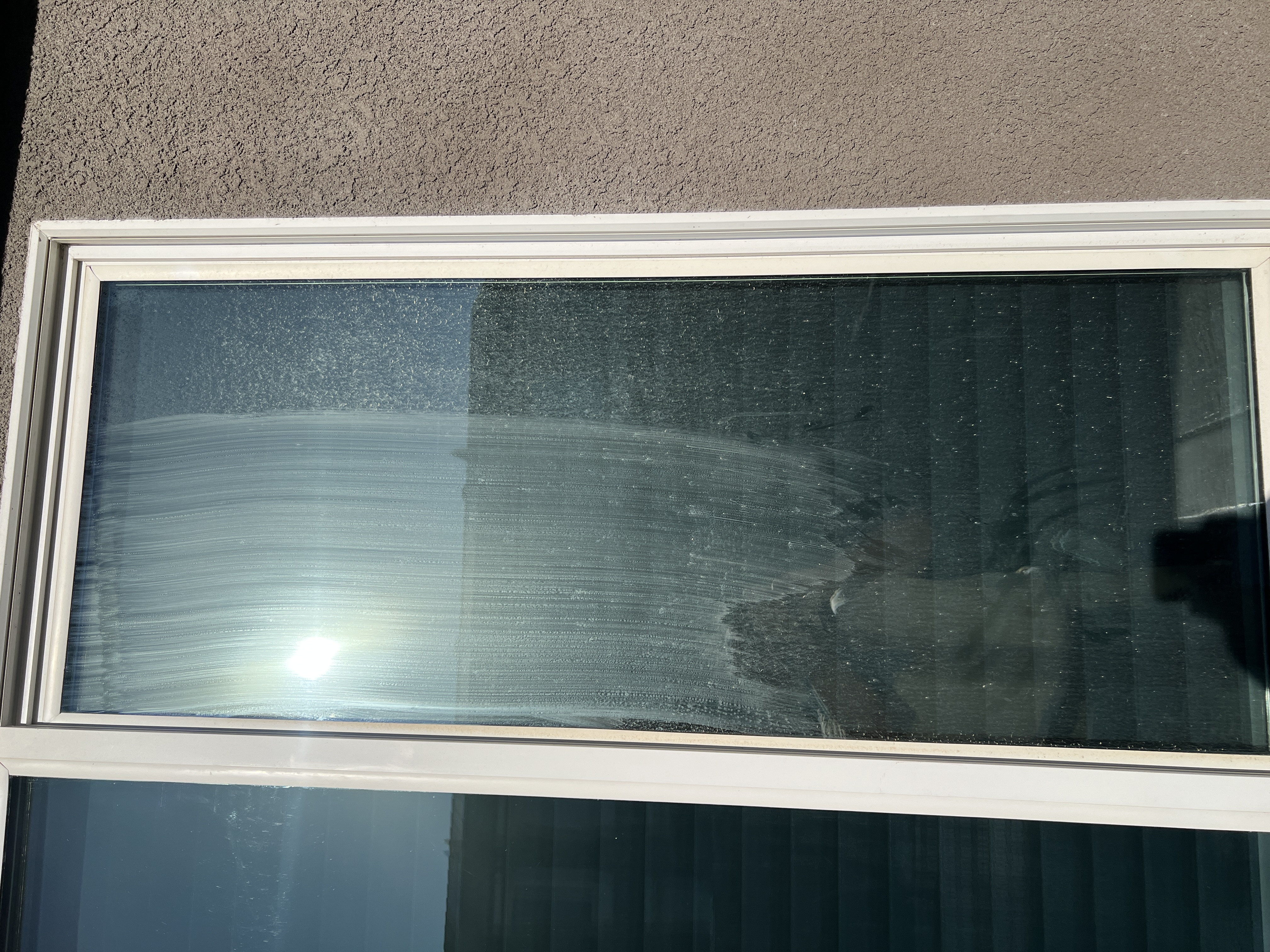 Hard water stained window before residential window cleaning Fresno CA